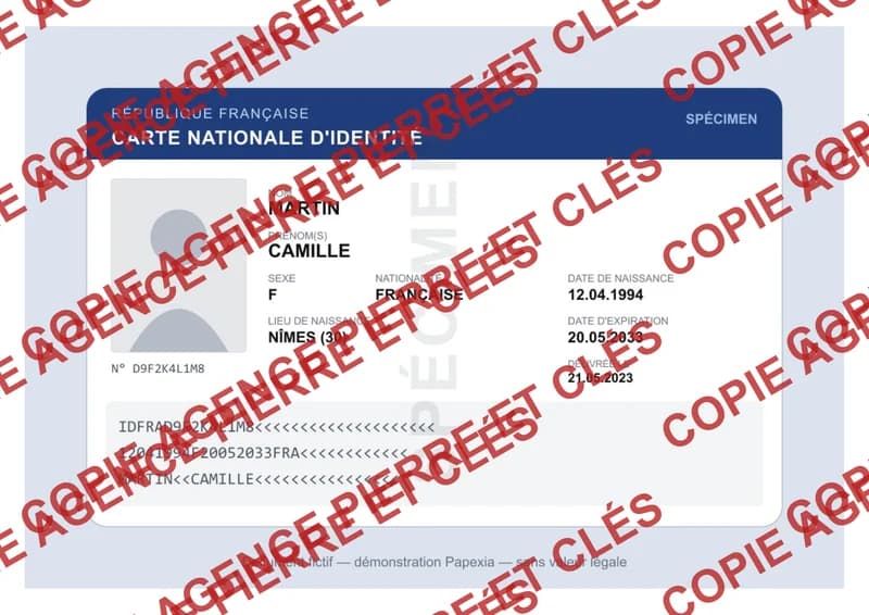 Carte d’identité fictive couverte d’un filigrane rouge épais et opaque : le nom, les dates et le numéro ne se lisent plus.